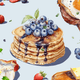 Decorative illustration of pancakes with blueberries and syrup